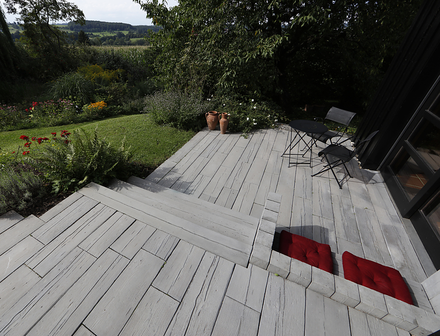 MAHORA Dielenstein, MAHORA Großstufe und MAHORA UNO in der Farbe Mooreiche auf einer Terrasse mit Sitzmöglichkeit aus MAHORA Elementen